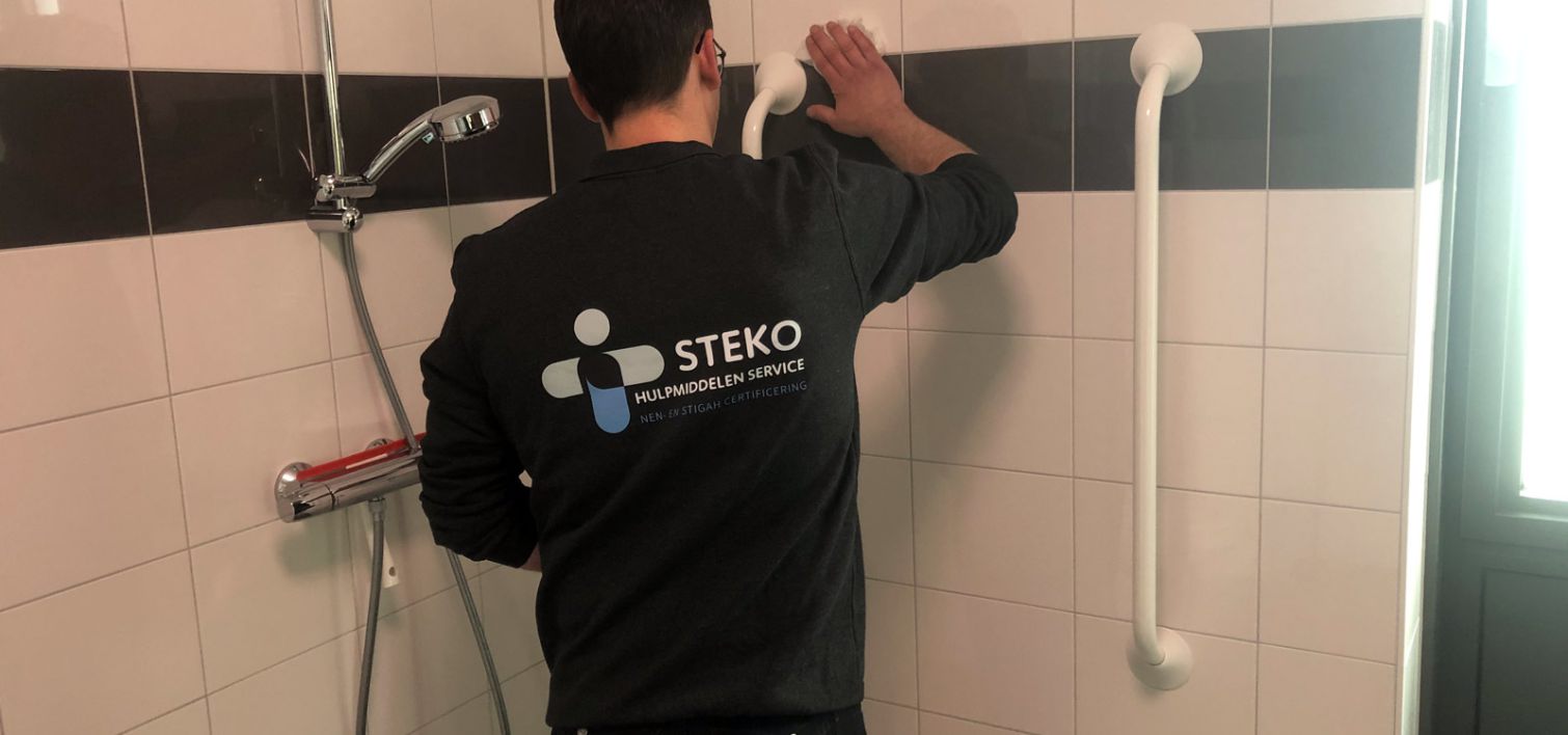 STEKO medewerker hangt douche wandsteun op